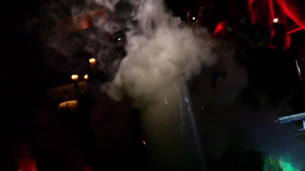 バーの氷の蒸気蒸気で暗闇の中での照明の下でカクテルのグラス — ストック動画