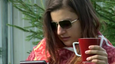 Tablet pc ile kahve okuma güneş gözlüğü çekim kız yüzüne kapatmak