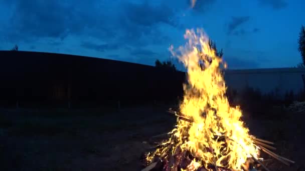 Gran fuego en el patio trasero, tarde cielo azul por la noche — Vídeos de Stock