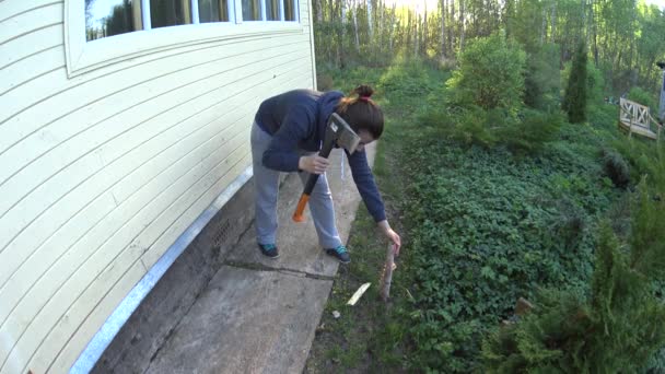 Divertida joven mujer picando madera en casa sobre hierba verde — Vídeo de stock