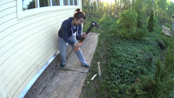 Lustige junge Frau schneidet, macht Axtklinge aus Holz — Stockvideo