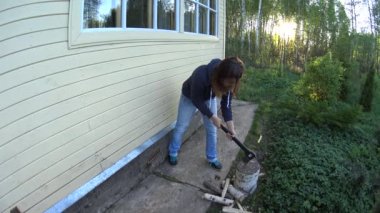 Komik genç kadın Chop huş ağacı ahşap Homestead yeşil çimenlerin üzerinde