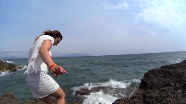 Söt flicka komma och sitta på rock hill på gränsen mellan havet och stirrade ut i en vattenförekomst, hår som flyger i vinden, beundra utsikten i Spanien, Mallorca, porträtt skott — Stockvideo