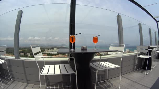 Two glasses with straw Aperol cocktail on table in sky bar balcony terrace, great landscape sea view — Stock Footage Two glasses with straw Aperol cocktail on table in sky bar balcony terrace, great landscape sea view Video Clip