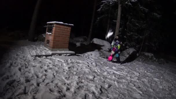 Flicka lek med leksak spade och snö på bakgården på vinternatt — Stockvideo