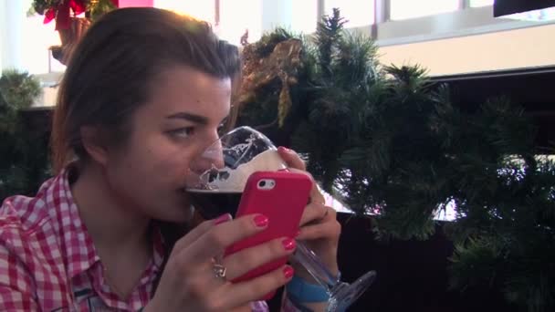 Meisje in slimme horloges te typen op een smartphone in bar en bier drinken — Stockvideo