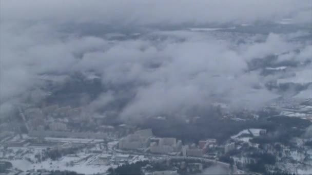 Paisaje nevado visto a través de una ventana mientras vuela en el cielo nublado — Vídeo de stock