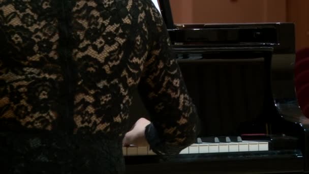 Rückseite Pianistin im schwarzen Kleid spielt Flügel auf Konzertbühne — Stockvideo