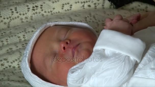 Newborn baby in overall sleeping in white bed, top view, closeup face — Stock Video