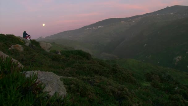 Ragazza turistica bottiglia di vino mentre seduto su una collina rocciosa — Video Stock