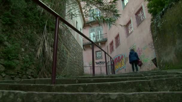 Ragazza con uno zaino salendo le scale sulla vecchia strada della città — Video Stock