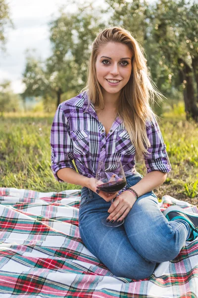 Chica con copa de vino descansando en el jardín — Foto de Stock