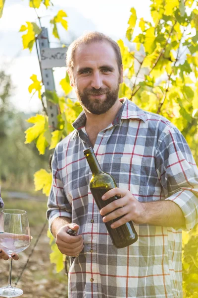 Man with Open Bottle Tasting Wine