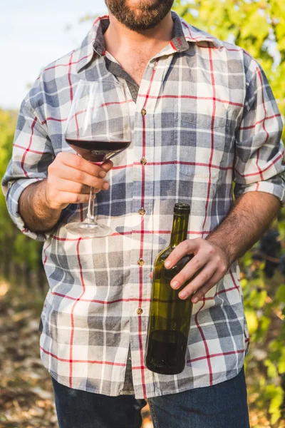 Man with Open Bottle Tasting Wine