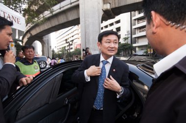 Thaksin Shinawatra gets off a car. clipart
