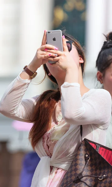 Female tourist takes a photograph with smart phone — Stock Photo, Image
