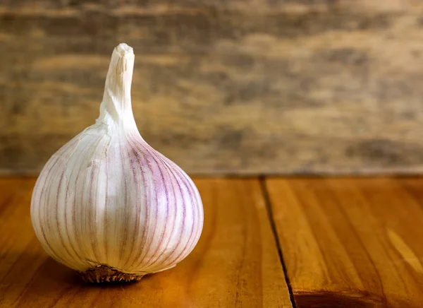 Garlic clove and garlic bulb on wooden background