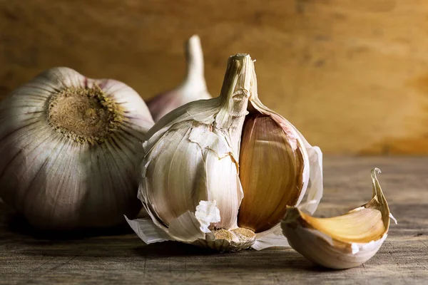 Knoflook, kruidnagel en knoflook bol op houten achtergrond — Stockfoto