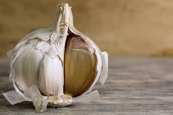 Garlic clove and garlic bulb on wooden background