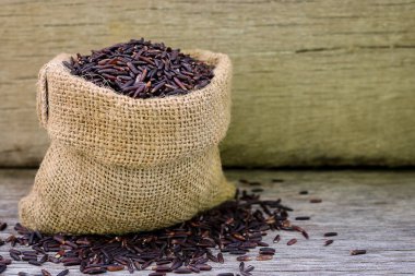 Ahşap arka plan kenevir torba Riceberry pirinç.