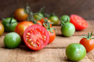 Ahşap zemin üzerine yeşil kök ile taze küçük domates