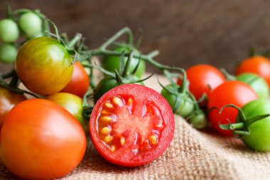 Ahşap zemin üzerine yeşil kök ile taze küçük domates