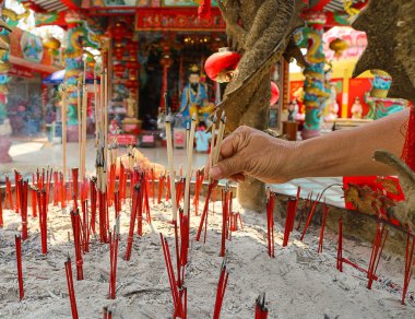 Women pray to Chinese gods by incense sticks at the shrine clipart