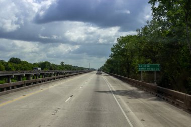 Kaldırımlı geniş bir yol, ormanın ortasında arabaların bir yaz günü geçtiği büyük yüksek köprüler. Louisiana 'daki Büyük Köprüler, Usa