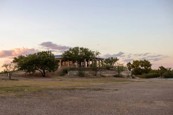 Casa Blanca Gölü, Teksas, Usa. Bir yaz akşamı ağaçların arasında kemerli eski bir bina..