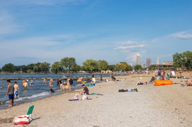 Erie Gölü, CIA, Ohio / Usa - 3 Eylül 2018: İnsanlar plajda dinleniyor, uzun gökdelenler uzaktan görülebiliyor. İnsanlar Cleveland 'daki Erie Gölü' nde İşçi Bayramı 'nı kutluyor..