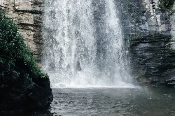 Beautiful big waterfall on summer day. Amazing landscape with waterfall, mountain river, rocks and green forest. Looking Glass waterfall, NC, USA