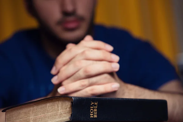 Jeune homme priant sur la Bible — Photo