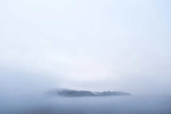 Bir köy bulutlar denizden ortaya çıkıyor. — Stok fotoğraf