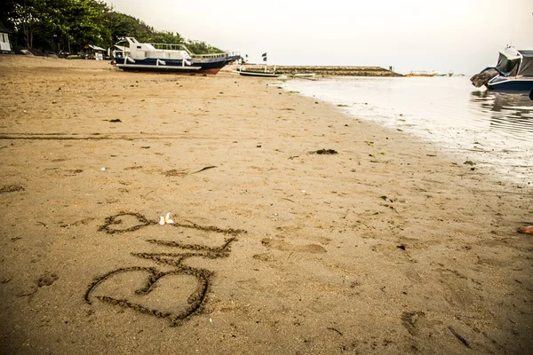 Bali Indonesia escrito en arena Sanur Beach puesta de sol — Foto de Stock