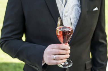Cam köpüklü şarap kırmızı şampanya takım elbise portre alyans tutan damat