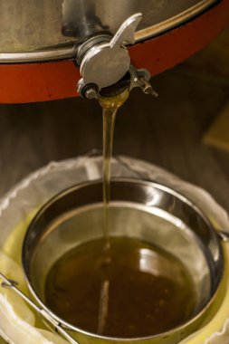 Bal ayıklamak, bal santrifüjden çıkıp bir kovaya sarkıyor.