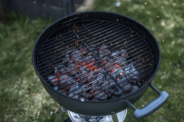 BBQ Grill Pit gloeien en Flaming Hot Houtskool briketten kolen voedsel achtergrond of textuur Close-Up bovenaanzicht — Stockfoto