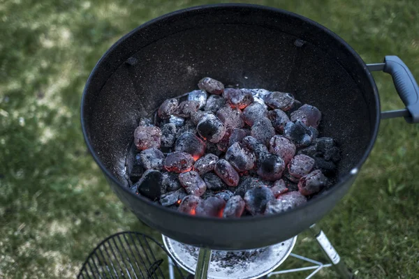 BBQ gril Pit zářící a planoucí horké uhlí brikety uhelné potravin pozadí nebo textury detail pohled shora — Stock fotografie