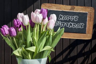 Ahşap kara tahta mutlu yıllar işareti güzel pinktulips kova bahar çiçek Lale kahverengi arka plan