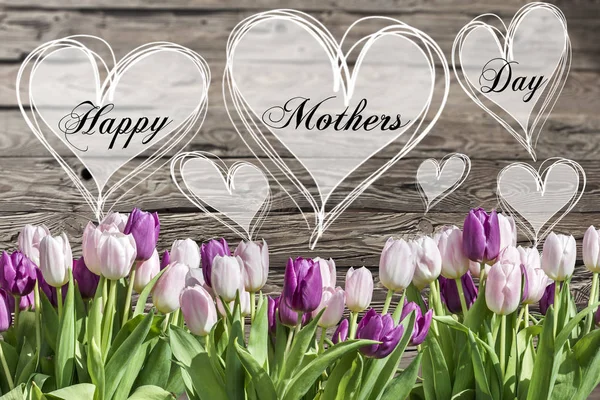 Happy mothers day text heart with pink and white tulips rustic wooden background greeting card spring flowers — Stock Photo, Image