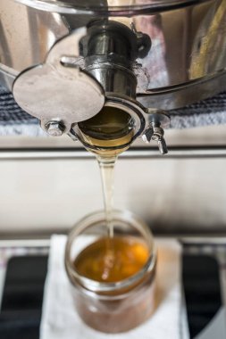 Cam içine taze altın yeni tatlım dolduruyor arıcı kavanozlar bir ölçekte ölçekler