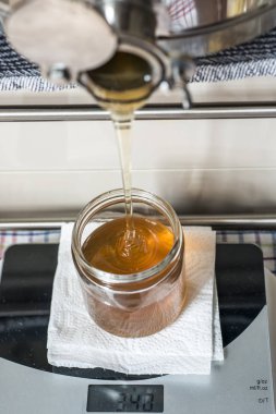 Cam içine taze altın yeni tatlım dolduruyor arıcı kavanozlar bir ölçekte ölçekler