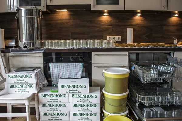 Alman Beehoney enerji bugünlük söyleyerek Cam Kavanoz beyaz karton kutular içine taze altın bal dolduruyor arıcı