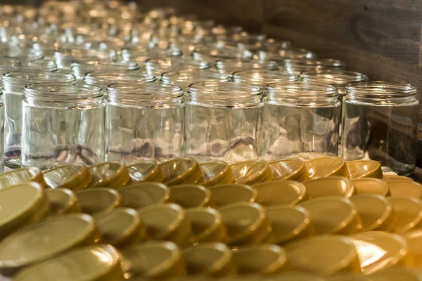 Muchos frasco de vidrio vidrios vacíos fila para mermelada miel con tapa tapas fondo abstracto bokeh — Foto de Stock
