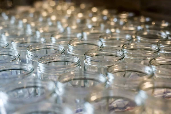 Muchos frasco de vidrio vasos vacíos fila para mermelada miel fondo abstracto bokeh — Foto de Stock