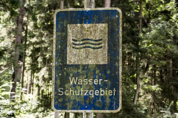 Old rusty vintage forgotten german sign in forest translation wasser schutzgebiet means water reserve — Stock Photo, Image