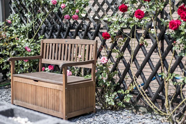 Tranquilo relaxar romântico jardim banco rodeado vermelho e rosa rosas arbustos flor — Fotografia de Stock
