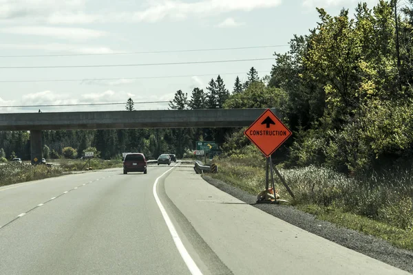 Canada Ontario 09.09.2017 Orange construction worker sign at road into the distance on trans canada — Stock Photo, Image