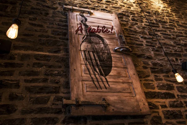 Старая заброшенная винтажная дверь ресторана с надписью "Стол и ложка вилки" на коричневой кирпичной стене — стоковое фото
