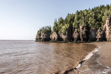 famous Hopewell Rocks geologigal formations at low tide biggest tidal wave Fundy Bay New Brunswick Canada clipart